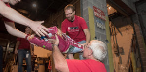 Photo of men unloading sacks of food from a truck.